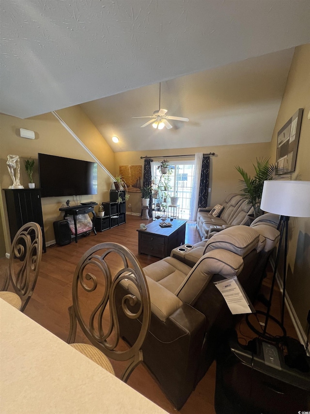 living room with a ceiling fan, vaulted ceiling, and wood finished floors