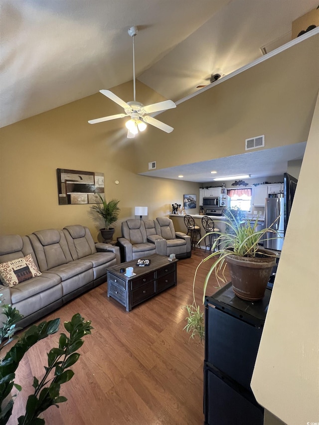 living room with high vaulted ceiling, ceiling fan, visible vents, and wood finished floors