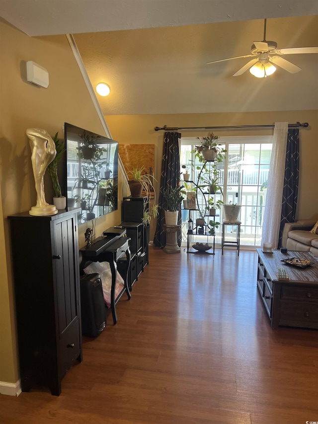 living area featuring ceiling fan, vaulted ceiling, and wood finished floors