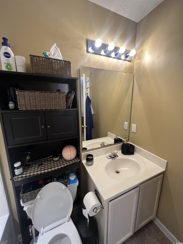 bathroom with vanity, toilet, and baseboards