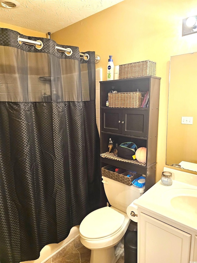 full bathroom with toilet, a shower with curtain, tile patterned flooring, a textured ceiling, and vanity