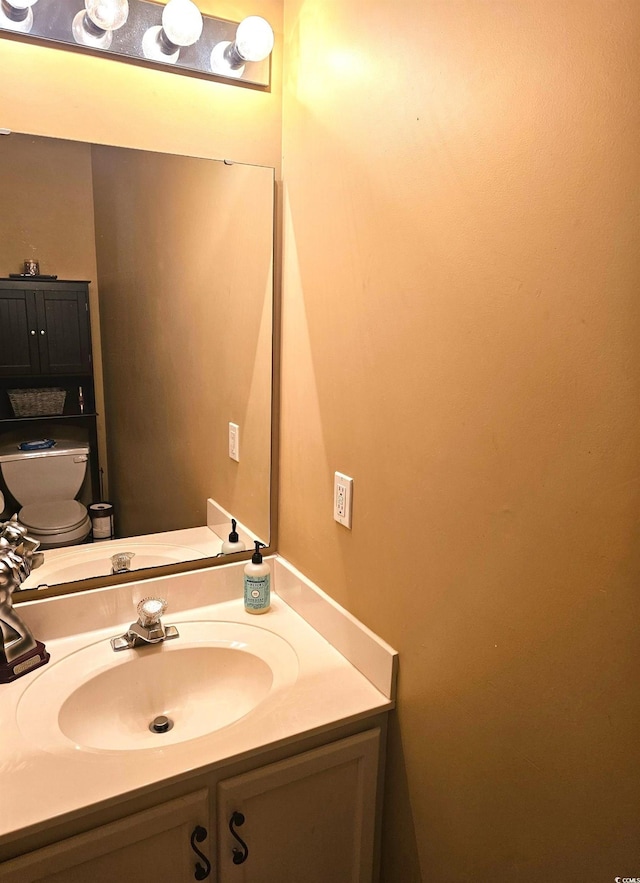 half bathroom with vanity and toilet