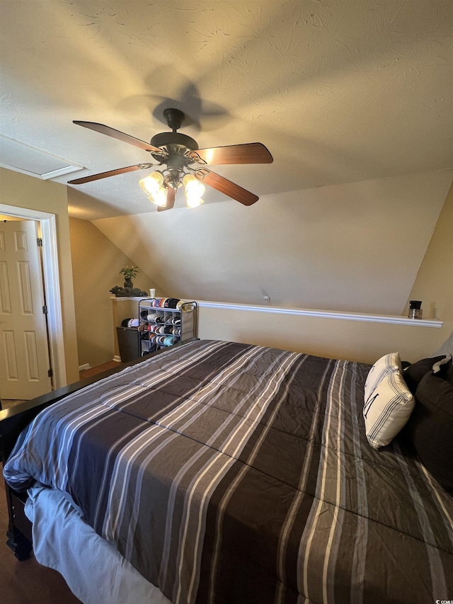 bedroom featuring ceiling fan, vaulted ceiling, and a textured ceiling