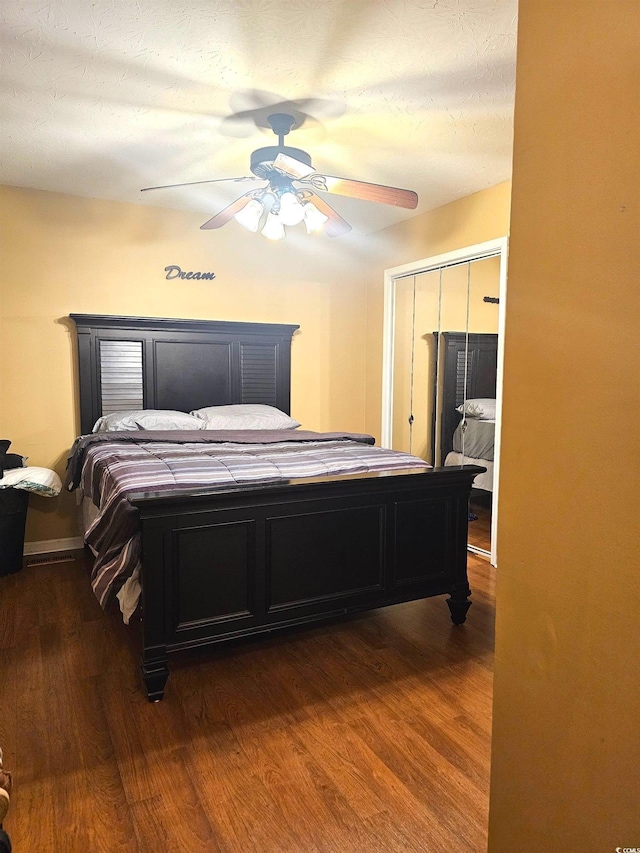 bedroom with a ceiling fan, a closet, and dark wood finished floors