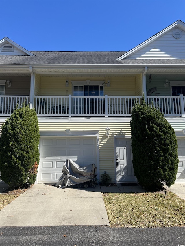 view of front of property with a shingled roof and concrete driveway