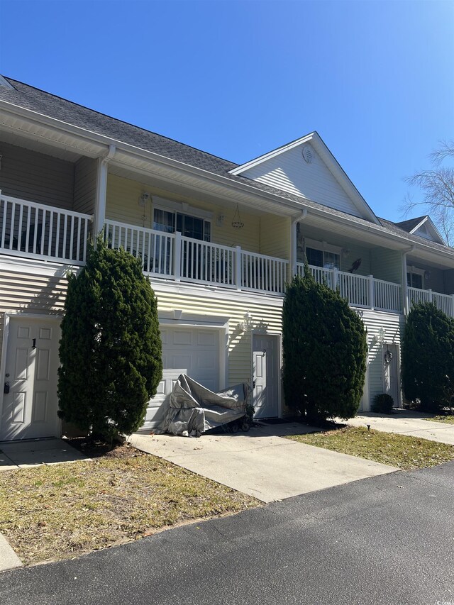 view of front facade with covered porch, concrete driveway, and an attached garage