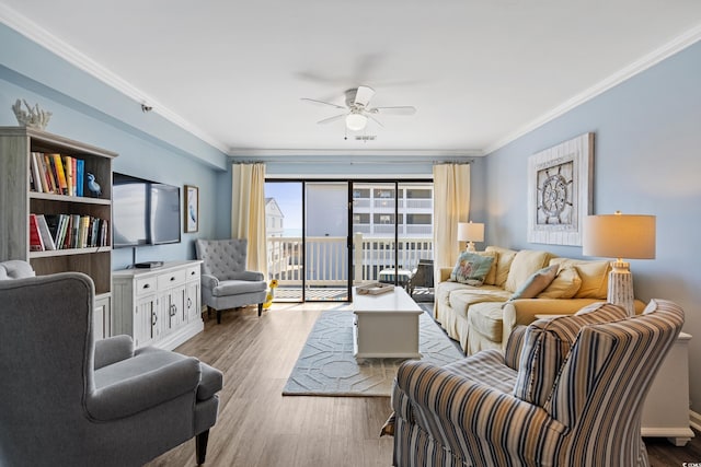 living room featuring ceiling fan, visible vents, crown molding, and wood finished floors