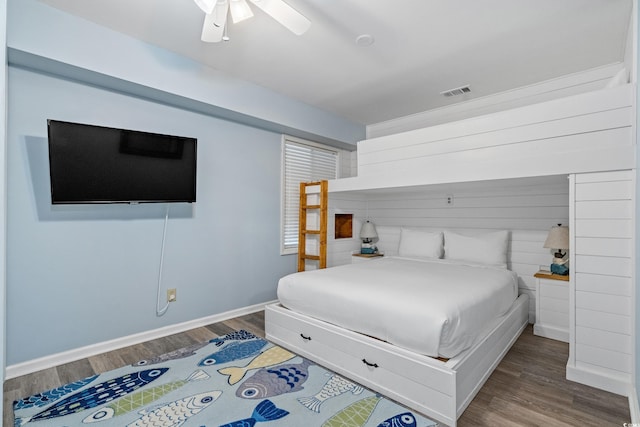 bedroom featuring a ceiling fan, baseboards, visible vents, and wood finished floors