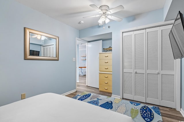 bedroom with a closet, baseboards, and wood finished floors