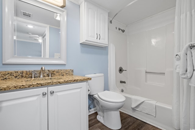 bathroom with toilet, wood finished floors, vanity, visible vents, and shower / bath combo