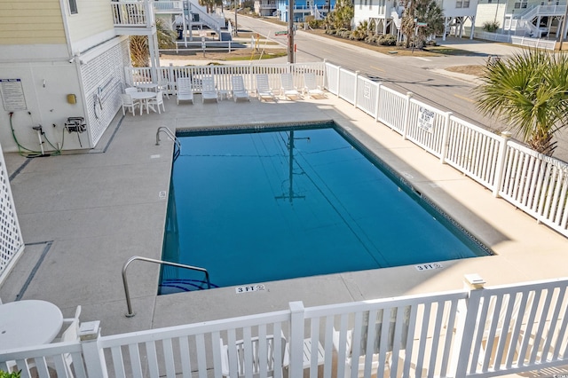 community pool featuring fence and a patio