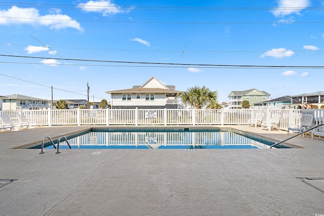 community pool with a residential view, a patio area, and fence