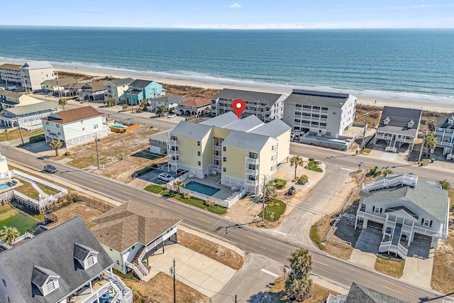 birds eye view of property featuring a water view and a beach view