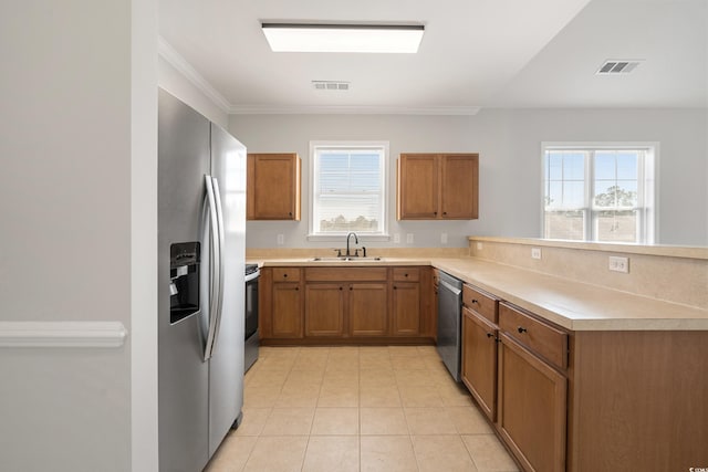 kitchen with visible vents, appliances with stainless steel finishes, brown cabinetry, and a sink