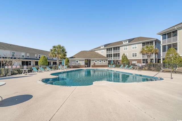 pool with a residential view, a patio, and fence