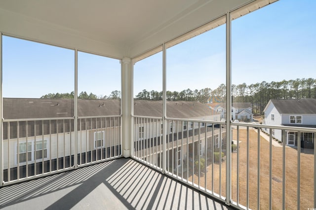 unfurnished sunroom with a residential view and a healthy amount of sunlight