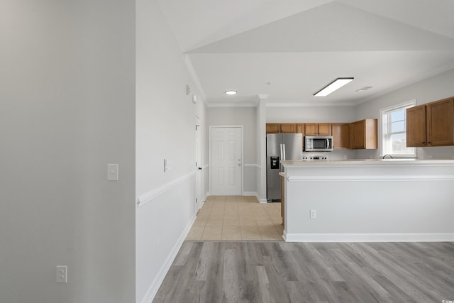 kitchen with baseboards, brown cabinets, stainless steel appliances, crown molding, and light countertops