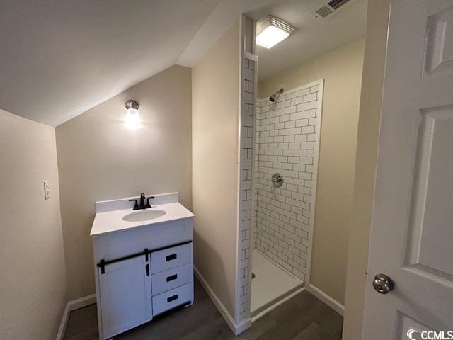 bathroom featuring lofted ceiling, visible vents, a stall shower, vanity, and baseboards