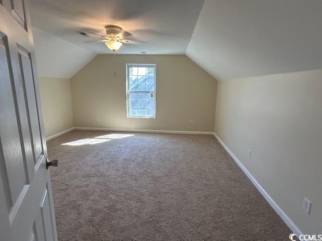 additional living space with a ceiling fan, carpet flooring, vaulted ceiling, and baseboards