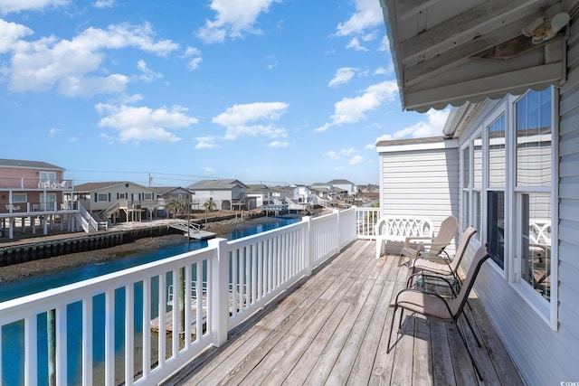 wooden deck featuring a water view and a residential view