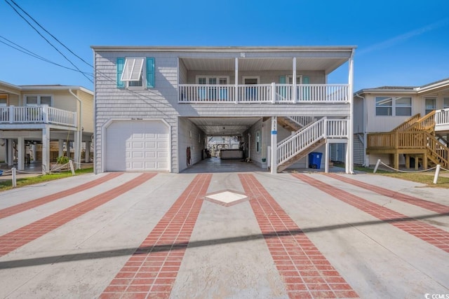 raised beach house featuring a carport, covered porch, stairs, and concrete driveway