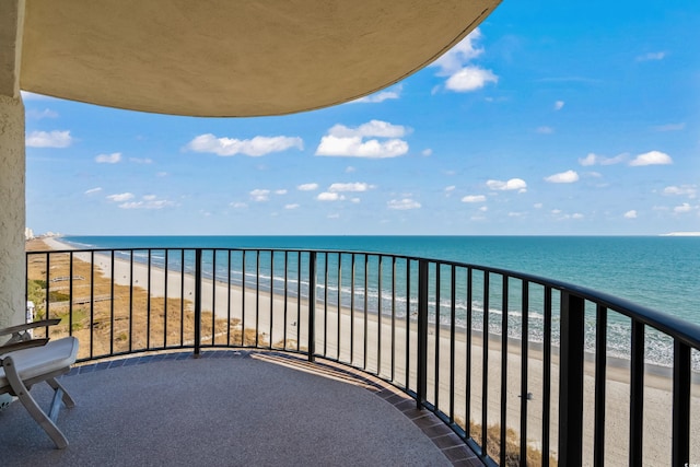 balcony with a water view and a beach view