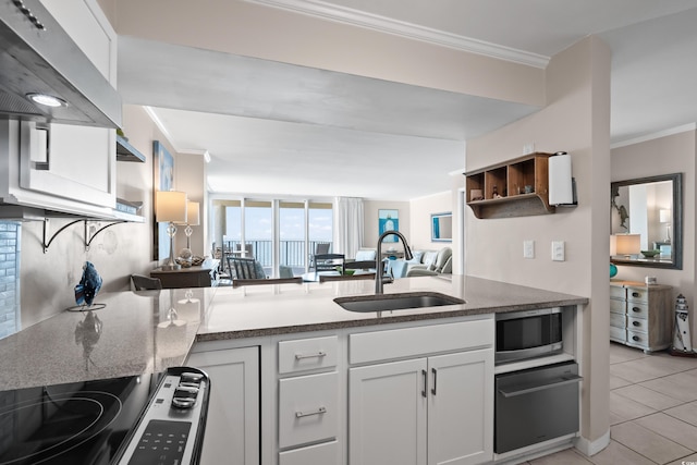 kitchen featuring stainless steel microwave, a sink, range, and crown molding