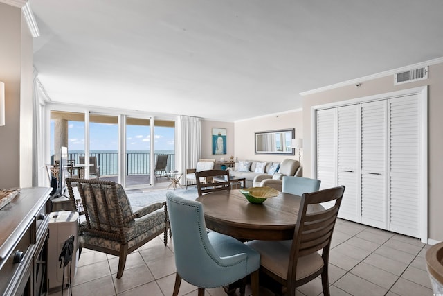 dining room with expansive windows, visible vents, crown molding, and light tile patterned flooring