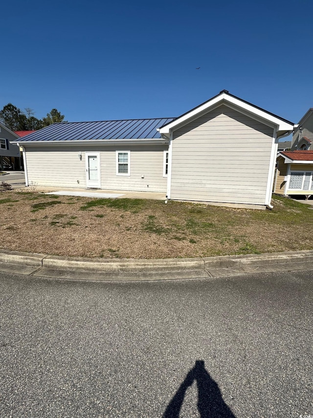 view of home's exterior featuring a standing seam roof and metal roof