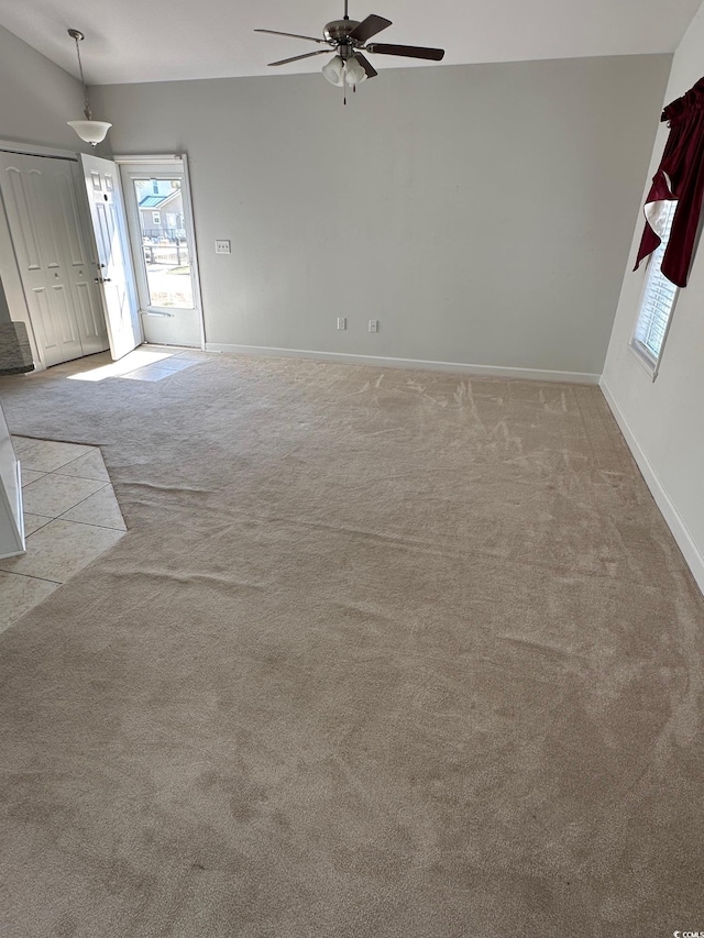 unfurnished living room featuring ceiling fan, baseboards, and carpet flooring