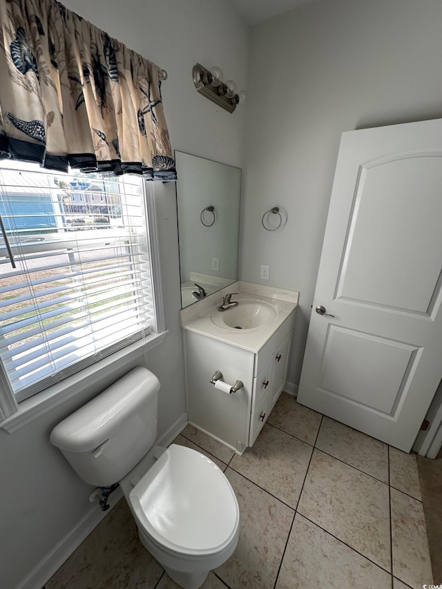 bathroom featuring toilet, vanity, baseboards, and tile patterned floors