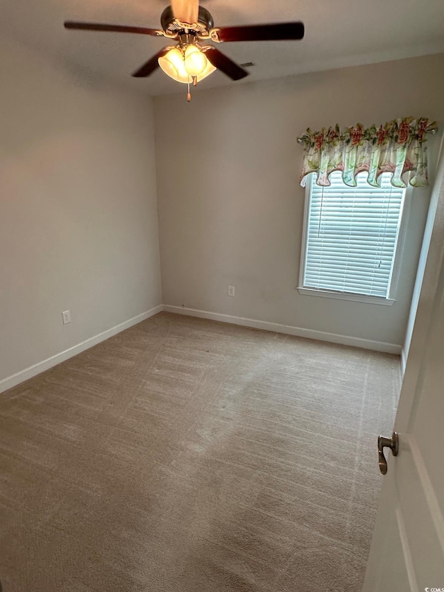 empty room featuring carpet flooring, a ceiling fan, and baseboards