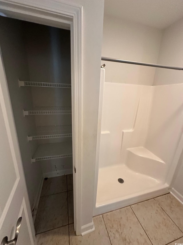 full bath with a shower stall and tile patterned floors