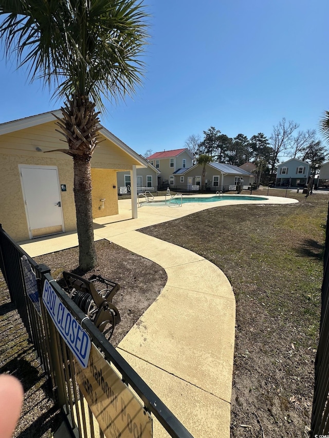 view of yard with a patio, a community pool, and fence