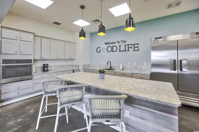 kitchen with finished concrete floors, visible vents, stainless steel appliances, and a sink