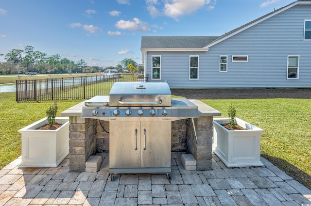 view of patio / terrace featuring a grill, fence, and an outdoor kitchen