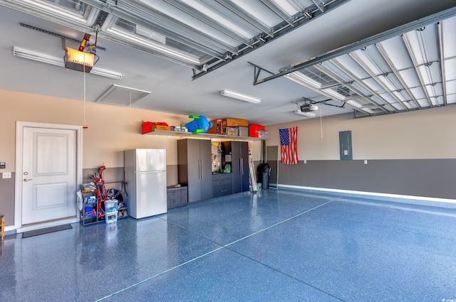 garage with electric panel, a garage door opener, and freestanding refrigerator