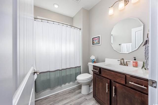 bathroom with toilet, wood finished floors, vanity, and a shower with curtain