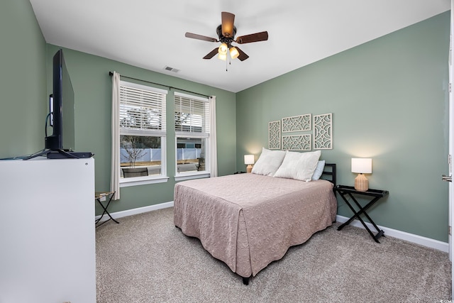 carpeted bedroom with baseboards, visible vents, and a ceiling fan