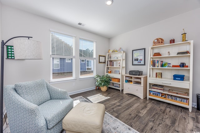 sitting room with dark wood-style floors, visible vents, and baseboards