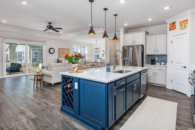 kitchen with appliances with stainless steel finishes, a wealth of natural light, white cabinets, and a sink