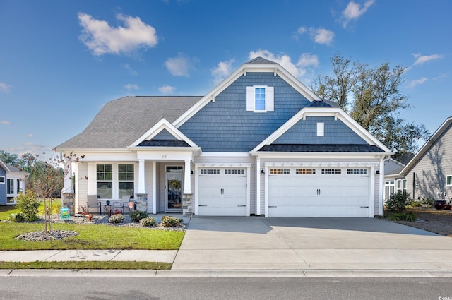 view of front of property with a garage, a front yard, covered porch, and driveway