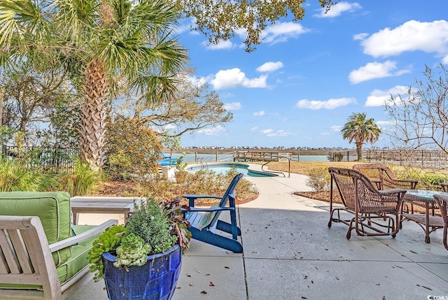 view of patio / terrace featuring a water view, fence, and an outdoor pool