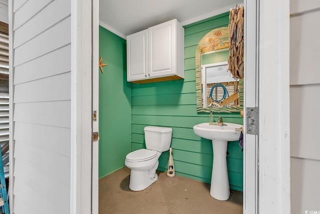 half bath with toilet and concrete flooring