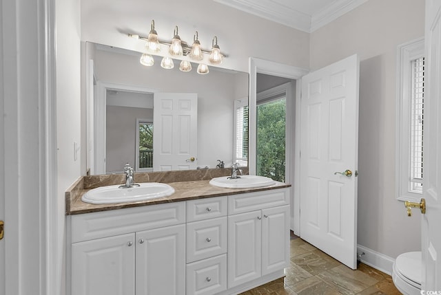 full bathroom with ornamental molding, a sink, toilet, and double vanity