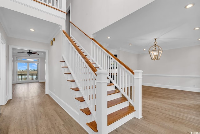 staircase featuring recessed lighting, baseboards, wood finished floors, and ornamental molding