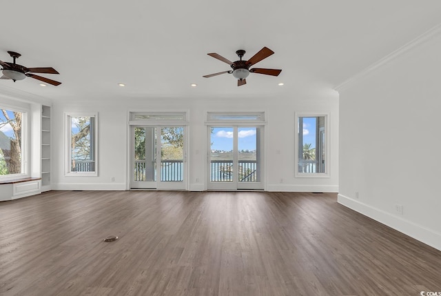 unfurnished living room with built in features, a wealth of natural light, crown molding, and a ceiling fan