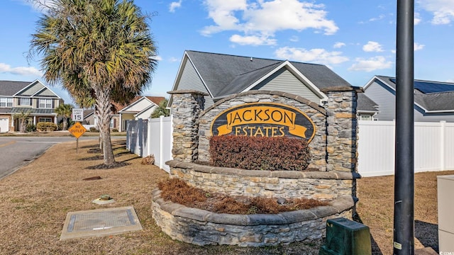 community sign with fence and a residential view