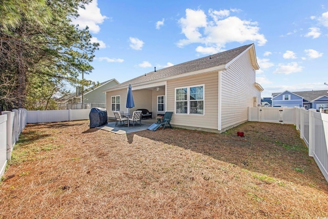 back of house with a patio, a lawn, and a fenced backyard