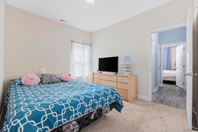 carpeted bedroom featuring visible vents and baseboards